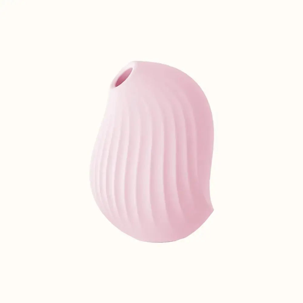 A compact, pink, ergonomic clit stimulator device designed for pleasure, with a smooth surface and body-safe silicone